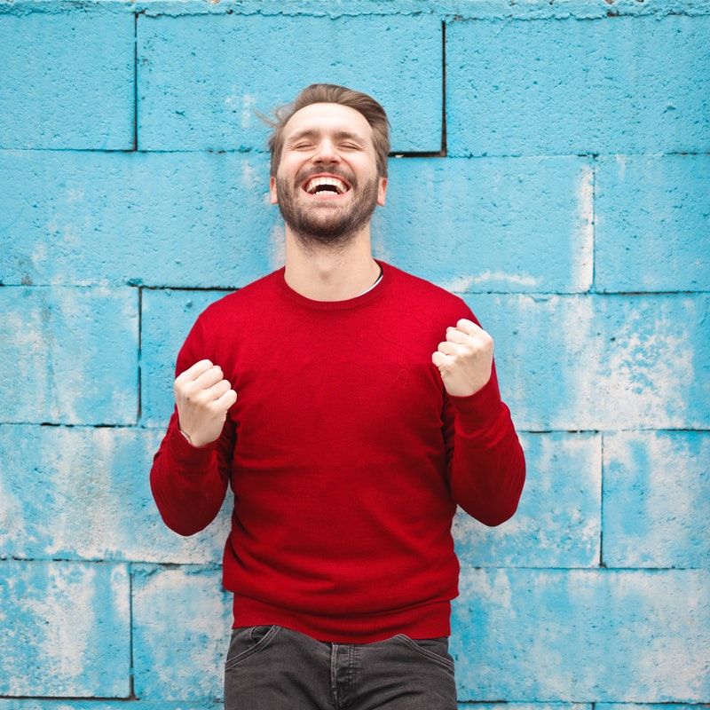 A photograph of a man with a huge smile on his face.