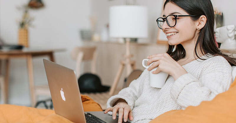 Woman relaxing and enjoying reading a high-quality webpage.