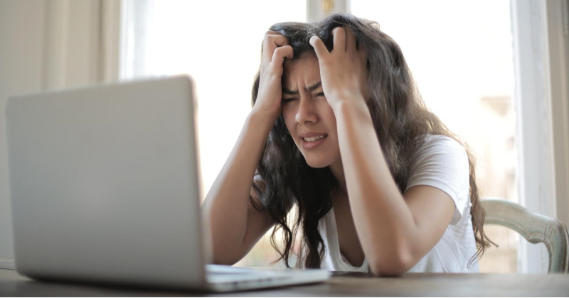 Woman frustrated looking at computer.